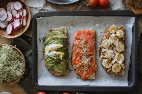 Tray of three assorted open-faced sandwiches with fresh toppings for a delicious meal.
